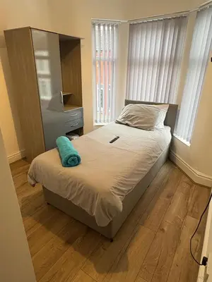 a bedroom with a bed with a blue towel on it at Anfield 5bed 5bath cosy group retreat in Liverpool