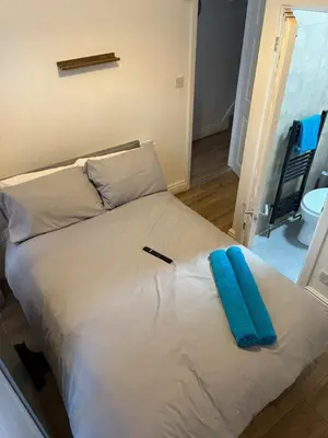 a white bed with a blue pillow on it at Anfield 5bed 5bath cosy group retreat in Liverpool