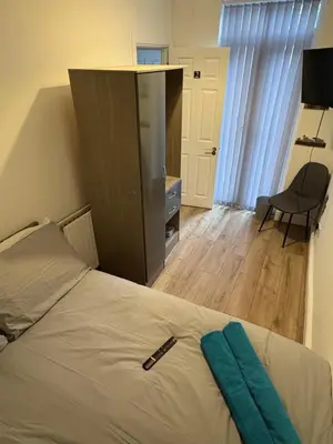 a bedroom with a bed with a blue towel on it at Anfield 5bed 5bath cosy group retreat in Liverpool