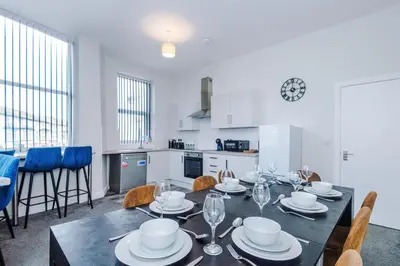 a dining room with a table with plates and wine glasses at Spacious 6-Bedroom Central Blackpool in Blackpool