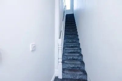 a stairway leading into a white room with a staircase at Spacious 6-Bedroom Central Blackpool in Blackpool