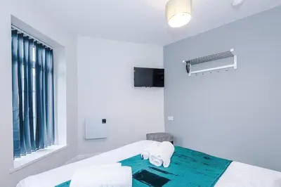a white room with a bed and a window at Spacious 6-Bedroom Central Blackpool in Blackpool