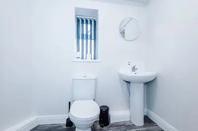 a white bathroom with a toilet and a sink at Spacious 6-Bedroom Central Blackpool in Blackpool