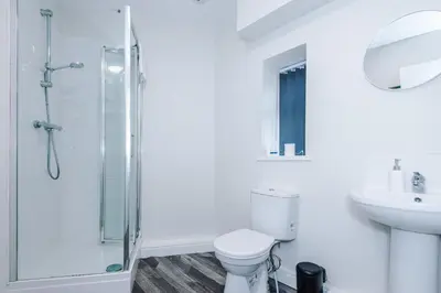 a bathroom with a shower and a toilet and a sink at Spacious 6-Bedroom Central Blackpool in Blackpool