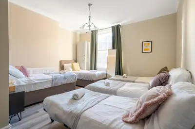 a room with three beds and a window at Central L1 Stay, Close to all Attractions, Parking Nearby in Liverpool