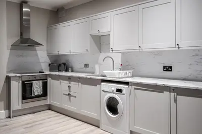 a kitchen with white cabinets and a washing machine at Central L1 Stay, Close to all Attractions, Parking Nearby in Liverpool