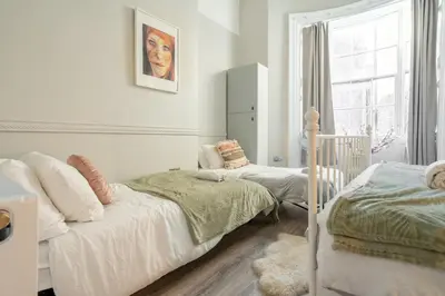 a white bedroom with two beds and a window at Central L1 Stay, Close to all Attractions, Parking Nearby in Liverpool