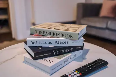 a stack of books sitting on a table next to a remote at Monthly & Weekly Offers , Pool Table , PS4 , Liverpool , 3 Bed House , Ideal For Contractors , Relocation & Family Stays in Litherland