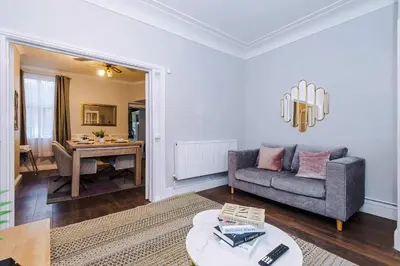 a living room with a couch and a table at Monthly & Weekly Offers , Pool Table , PS4 , Liverpool , 3 Bed House , Ideal For Contractors , Relocation & Family Stays in Litherland