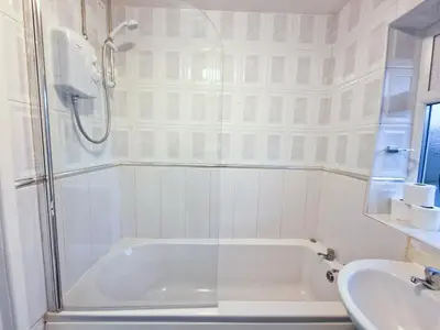 a white bathroom with a tub and a sink at Amazing Spacious 3BDR Home Near LFC Stadium in Liverpool