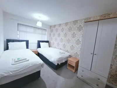 a small bedroom with two beds and a cabinet at Amazing Spacious 3BDR Home Near LFC Stadium in Liverpool