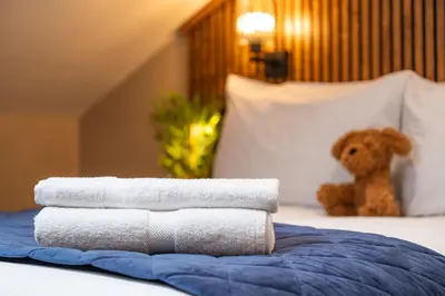 a pile of towels on a bed with a teddy bear at The Terrace - A St David Aparthotel in Barrow