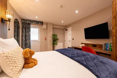 a bedroom with a teddy bear sitting on a bed at The Terrace - A St David Aparthotel in Barrow