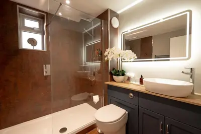a bathroom with a sink and a toilet and a mirror at The Terrace - A St David Aparthotel in Barrow