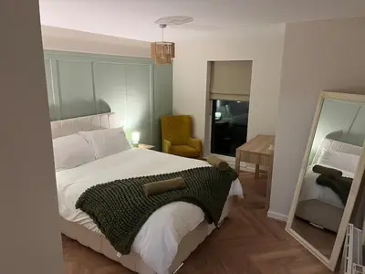 a bedroom with a large bed and a mirror at Sustainable Habitats- Berkley House apartment in Blackpool
