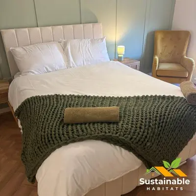 a bed with a green blanket on top of it at Sustainable Habitats- Berkley House apartment in Blackpool
