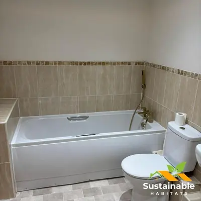 a bathroom with a white bath tub next to a toilet at Sustainable Habitats- Berkley House apartment in Blackpool