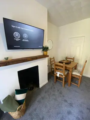 a living room with a flat screen tv above a fireplace at Slick Space for a Wigan Stay - 5 Minutes from M6 and M58 Motorways in Pemberton