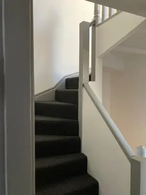 a staircase in a house with black carpet at Skylight Loft, 2 bed apartment, central Lancaster in Lancaster