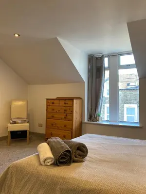 a bedroom with a bed with a dresser and a window at Skylight Loft, 2 bed apartment, central Lancaster in Lancaster