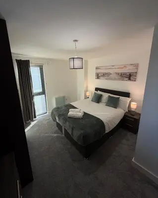 a bedroom with a large bed and a window at Central Liverpool 2-Bed Balcony Apartment by StaySavvy Accommodation in Liverpool