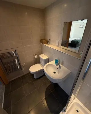 a bathroom with a toilet and a sink and a mirror at Central Liverpool 2-Bed Balcony Apartment by StaySavvy Accommodation in Liverpool