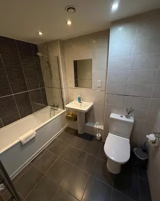 a bathroom with a toilet and a sink and a tub at Central Liverpool 2-Bed Balcony Apartment by StaySavvy Accommodation in Liverpool