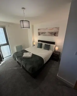 a bedroom with a large bed and two lamps at Central Liverpool 2-Bed Balcony Apartment by StaySavvy Accommodation in Liverpool