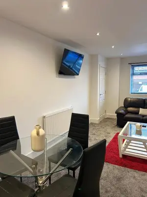 a living room with a glass table and a couch at Cosy flat Lytham St Annes - Sleeps 2 with parking in Lytham St Annes