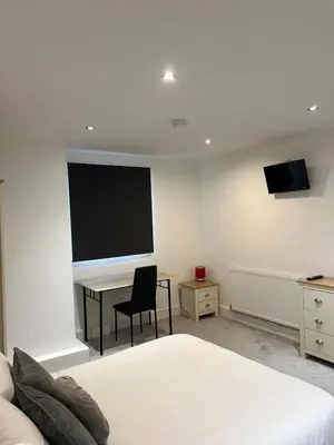 a bedroom with a desk and a tv on the wall at Cosy flat Lytham St Annes - Sleeps 2 with parking in Lytham St Annes
