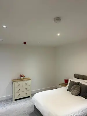 a white bedroom with a bed and a dresser at Cosy flat Lytham St Annes - Sleeps 2 with parking in Lytham St Annes
