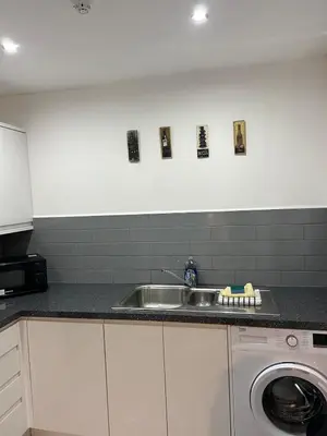 a kitchen with a sink and a washing machine at Cosy flat Lytham St Annes - Sleeps 2 with parking in Lytham St Annes