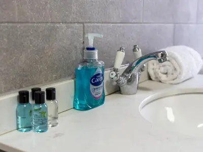 a bathroom sink with a bottle of cleaning detergent on it at Large House in Central Ulverston Sleeps 10 - Pass the Keys in Ulverston