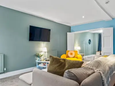 a living room with a couch and a tv on a wall at Large House in Central Ulverston Sleeps 10 - Pass the Keys in Ulverston