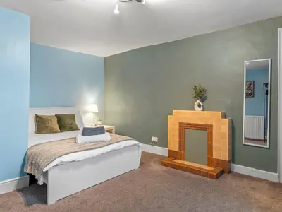 a bedroom with a bed and a fireplace at Large House in Central Ulverston Sleeps 10 - Pass the Keys in Ulverston