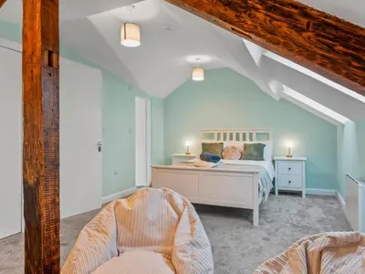 a bedroom with a bed and a chair at Large House in Central Ulverston Sleeps 10 - Pass the Keys in Ulverston