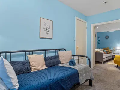 a bedroom with blue walls and a bed with pillows at Large House in Central Ulverston Sleeps 10 - Pass the Keys in Ulverston