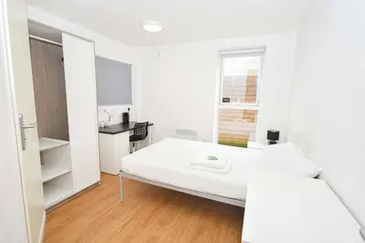 a white room with a bed and a window at Modern & Convenient 4 Bed Apartment in Liverpool in Liverpool