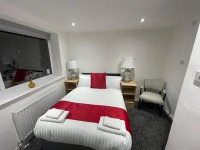 a bedroom with a red and white bed and a window at NEW PCK Thas Hotel BLACKPOOL in Blackpool