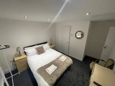 a bedroom with a bed and a clock on the wall at NEW PCK Thas Hotel BLACKPOOL in Blackpool