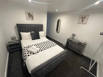 a bedroom with a bed and two night stands at NEW PCK Thas Hotel BLACKPOOL in Blackpool
