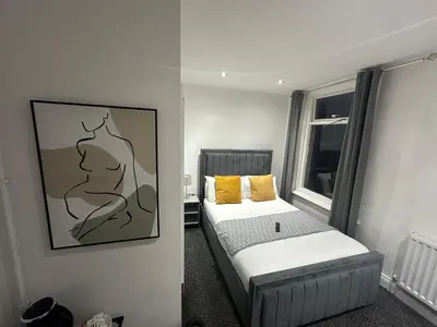a small bedroom with a bed and a picture on the wall at NEW PCK Thas Hotel BLACKPOOL in Blackpool