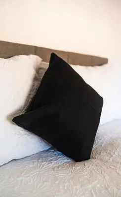 a black pillow sitting on top of a bed at Cosy & Stylish Home in St Helens