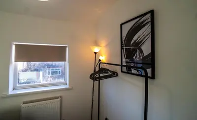 a room with a light on the wall and a window at Cosy & Stylish Home in St Helens