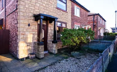 a brick house with a door on the side of it at Cosy & Stylish Home in St Helens