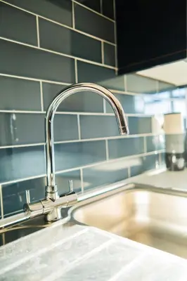 a kitchen sink with a faucet on top of it at Cosy & Stylish Home in St Helens