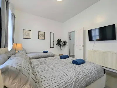 a living room with two beds and a flat screen tv at Large 2-Bed Near City Centre & Anfield Parking in Liverpool