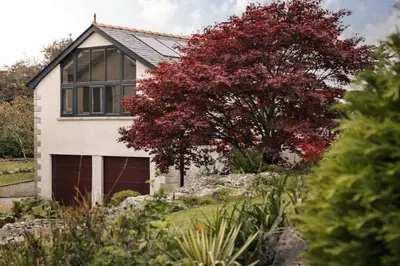 a house with a red tree in front of it at The Lookout - Ridgestone in Grange Over Sands