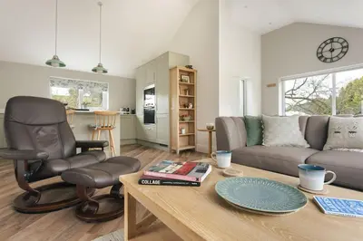 a living room with a chair a couch and a table at The Lookout - Ridgestone in Grange Over Sands