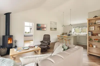a living room with a couch and a fireplace at The Lookout - Ridgestone in Grange Over Sands